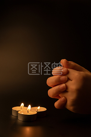 对着蜡烛祈祷的哀伤者
